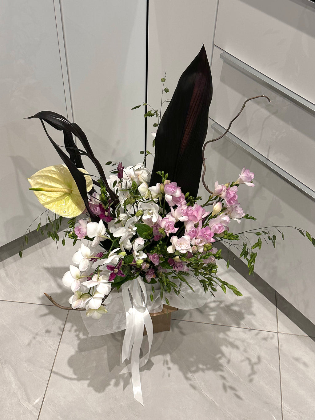 Luxusní stříbrná váza v kombinaci s květinami na míru ve tmavých tonech, dle přání od floristu v květinářství Maison Pétales Praha ČR